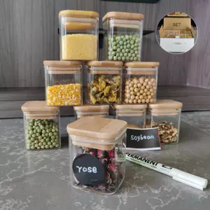 Borosilicate glass jars with natural bamboo lids and chalkboard labels, storing pasta and cereal.