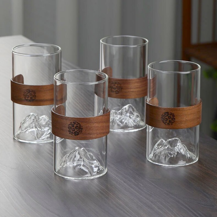 Unique mountain-inspired glass cup featuring a protective wooden sleeve, ideal for hot or cold beverages, modern kitchen décor