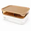Two sizes of rectangular stackable food storage containers with beige lids, transparent amber sections and detachable drain trays.
