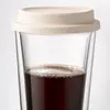 Clear 450ml glass coffee tumbler featuring a removable cream colored silicone lid and double wall construction