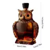Decorative owl-shaped glass decanter filled with amber whiskey