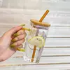Modern square-shaped clear glass cup with a pop of color lid and straw. Ergonomic handle design, ideal for office desk or home use.