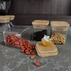 Stackable square glass canisters neatly organized in a kitchen cabinet for efficient storage.