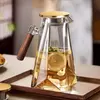 Wooden handle glass pitcher with modern transparent body and pouring spout
