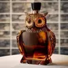 Decorative owl-shaped glass decanter filled with amber whiskey