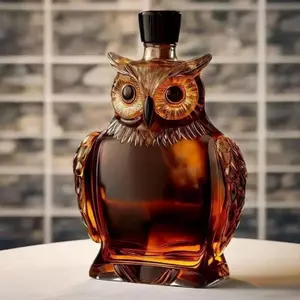 Decorative owl-shaped glass decanter filled with amber whiskey
