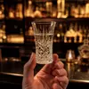 Flared whiskey shot glass featuring a 50mm opening and decorative clear body