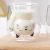 cute cat shaped double wall glass mug holding milk on wooden table