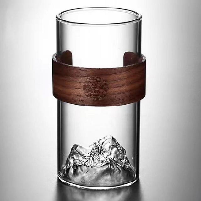 Clear glass cup with 3D mountain-shaped base and wooden sleeve, perfect for tea, water, or juice, stylish and safe for home use