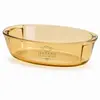 Amber oval borosilicate glass baking dish with integrated side handles and 1.7L capacity for oven cooking.