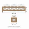 Twelve small clear shot glasses with natural wood display and serving rack
