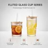 Clear ribbed drinking glass with lid straw ice and lemon for refreshing cold drinks
