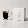 Modern transparent coffee mug with rounded clear glass handle and visible inner and outer glass walls