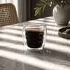 Rounded double wall coffee glass filled with dark espresso and golden crema highlighting the ripple inner chamber