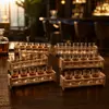 Clear liquor shot glasses with two-tier wooden rack for organized serving and presentation