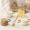 Cartoon glass mug with colored handle and playful printed design