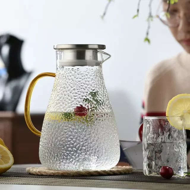 Elegant hammered glass beverage pitcher with gold handle for modern kitchen and dining use