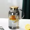 Elegant glass water pitcher featuring a stainless steel lid and ergonomic handle