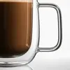 Modern rounded double wall glass coffee mug filled with coffee and topped with a light foam layer