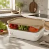 Top and side views of a rectangular food storage container featuring a brown toned fitted lid and space saving stackable design.
