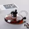 Elegant flat glass teapot featuring a transparent body and integrated glass tea filter
