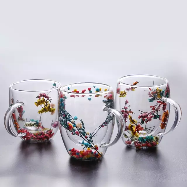 Jiateng double-wall insulated glass cups with real dried flowers inside, perfect for serving milk tea or herbal tea.