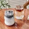 Modern wave ribbed glass cup filled with iced coffee on a clean tabletop