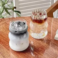 Modern wave ribbed glass cup filled with iced coffee on a clean tabletop