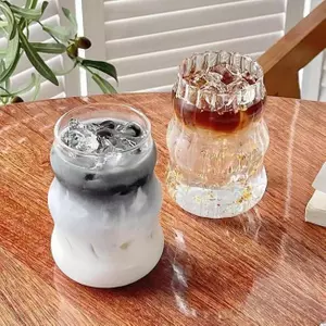 Modern wave ribbed glass cup filled with iced coffee on a clean tabletop