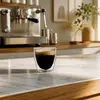 Clear handleless double wall espresso cup with a compact rounded silhouette and smooth circular rim
