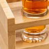 Clear whiskey tasting glasses arranged on a two-level wooden display holder