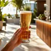 tall cold drink glass with embossed body and flared stable base