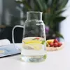 Space-saving glass water jug with integrated cup for hotels, offices, and bedrooms
