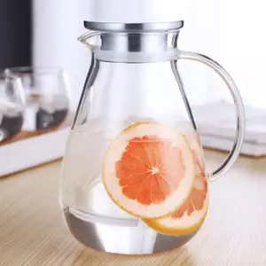 BPA-free borosilicate glass pitcher with stainless steel lid, filled with water and fresh grapefruit slices, demonstrating professional-grade clarity and durability.