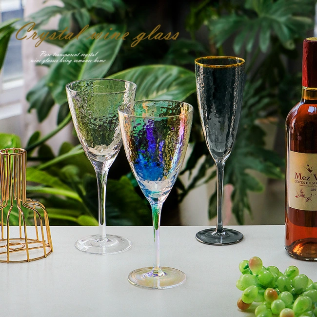 Decorative iridescent wine glasses displayed with modern table setting and wine bottle