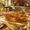 Side view of a 7cm high amber borosilicate glass oven dish with a shallow oval profile for casseroles and roasted foods.