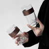 Clear glass cup with realistic mountain-shaped bottom and ergonomic wooden sleeve, perfect for stylish home or office use