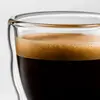 Transparent mini espresso glass featuring a rounded inner beverage chamber and double wall construction